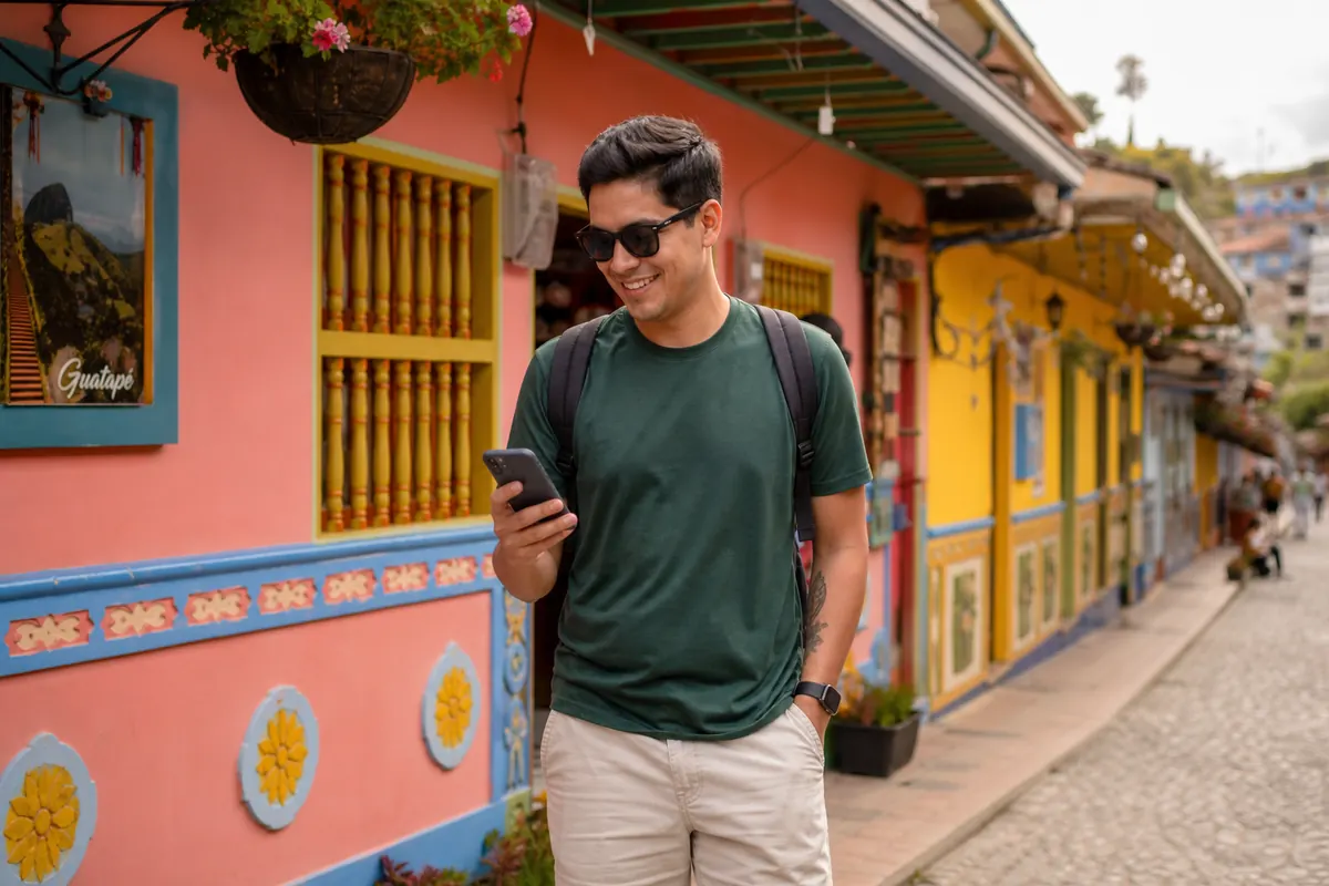 Traveler connected on his smartphone in the streets of Guatapé, Colombia.